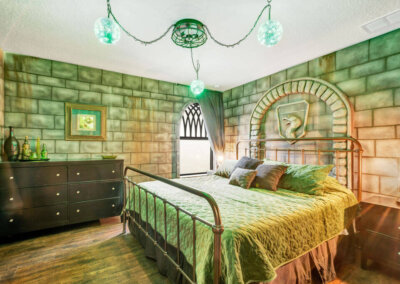 Green and black snake room with green lighting, snake wall-carving, and large king-sized bed