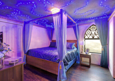 Wizards Way blue royalty room with large king-sized bed, beautiful blue and gold decorations, and blue strung lighting